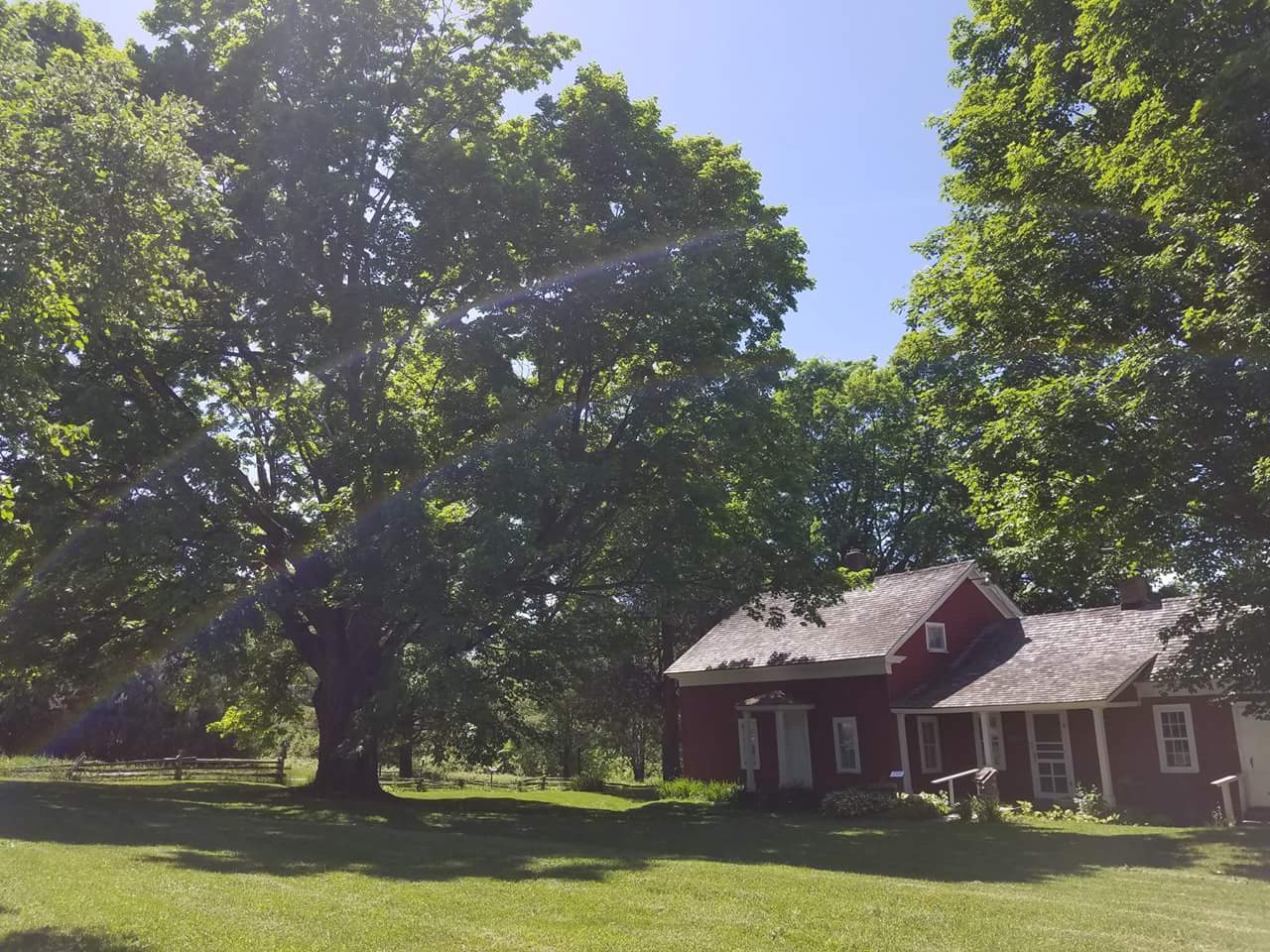 Almanzo Wilder’s red boyhood farmhouse beneath trees near Malone, New York.
