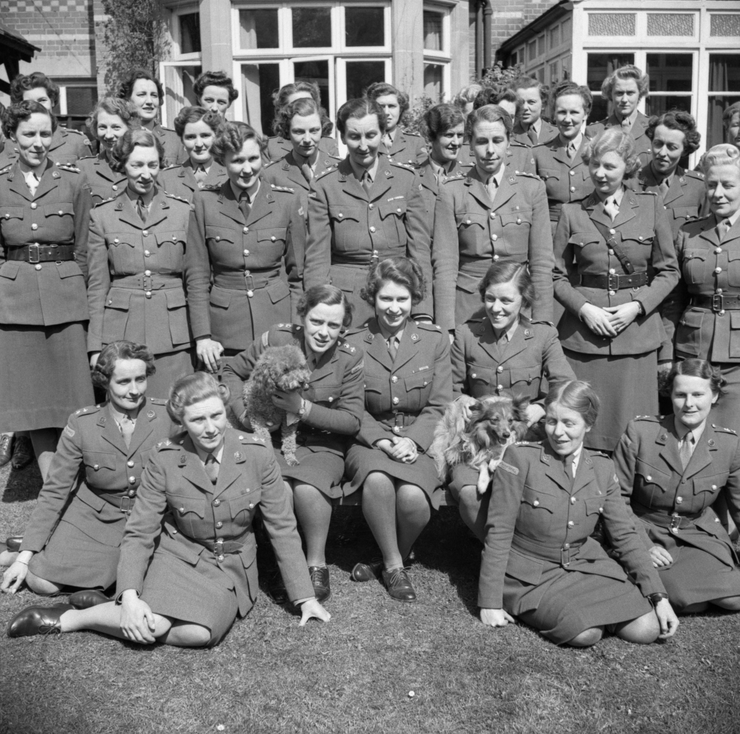 Princess Elizabeth seated at the centre of a group of Auxiliary Territorial Service personnel in April 1945.