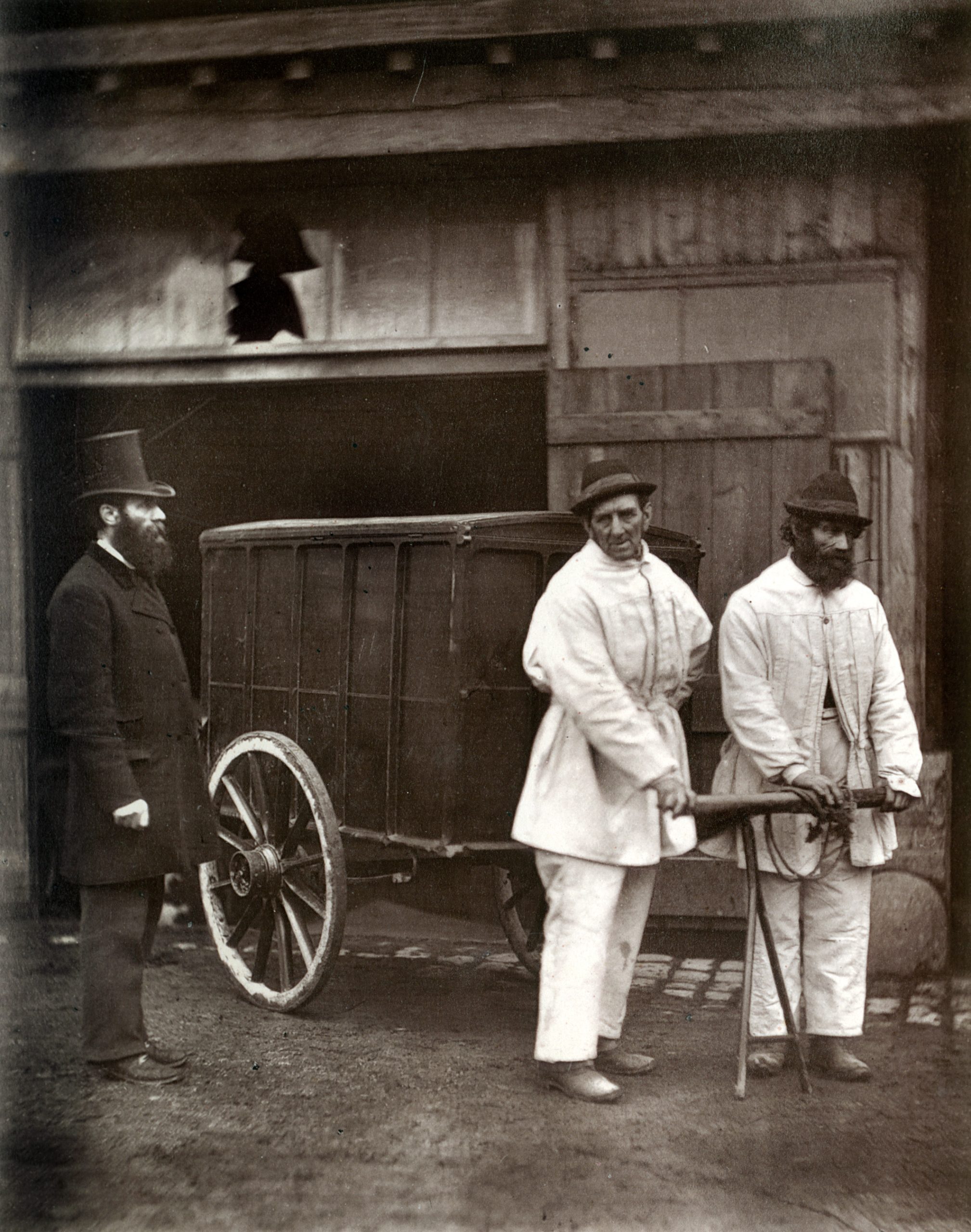 Public disinfectors with a closed handcart and protective outer clothing in Victorian London, 1877
