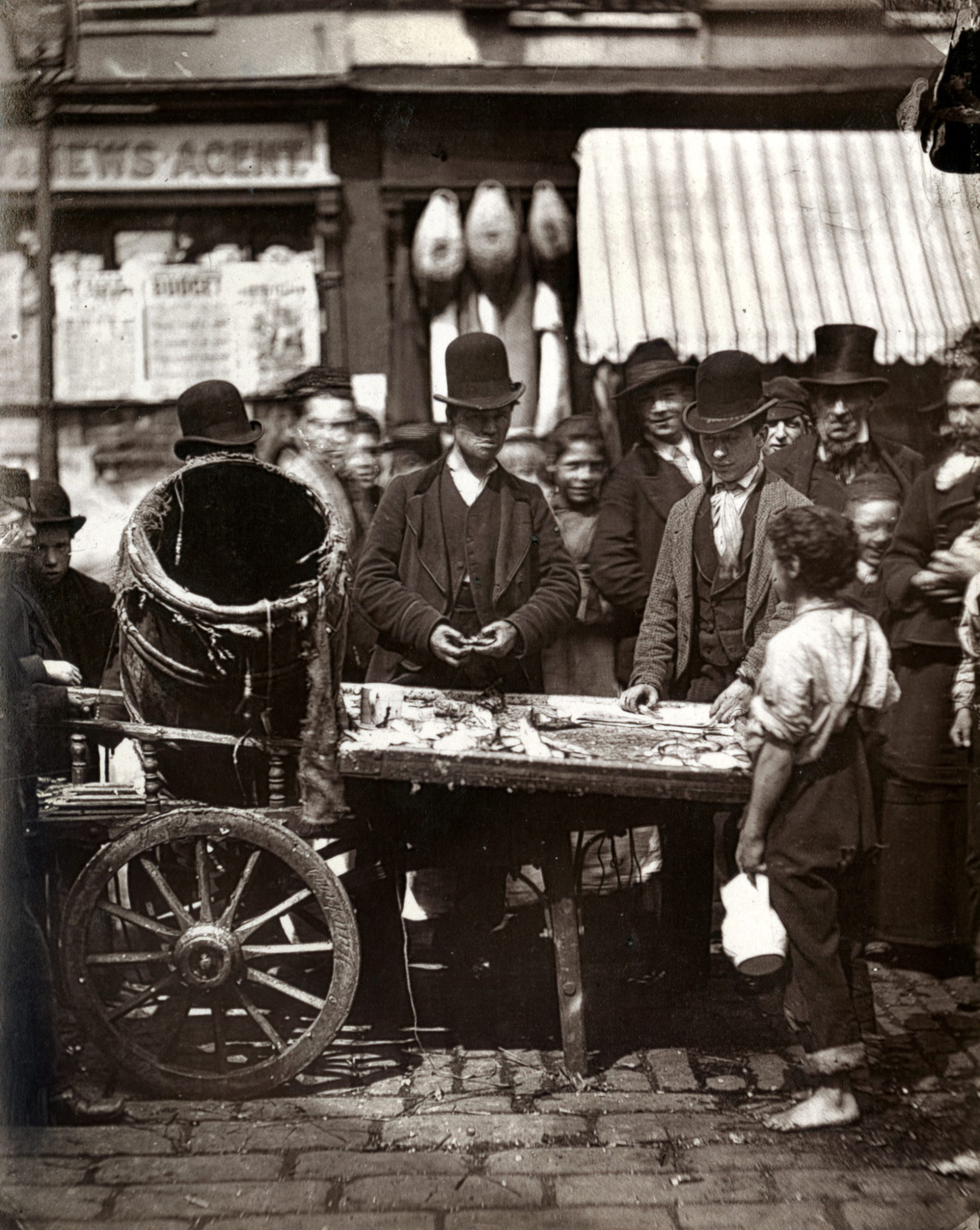 London’s poor buying and selling herrings at Joseph Carney’s street fish stall, 1877
