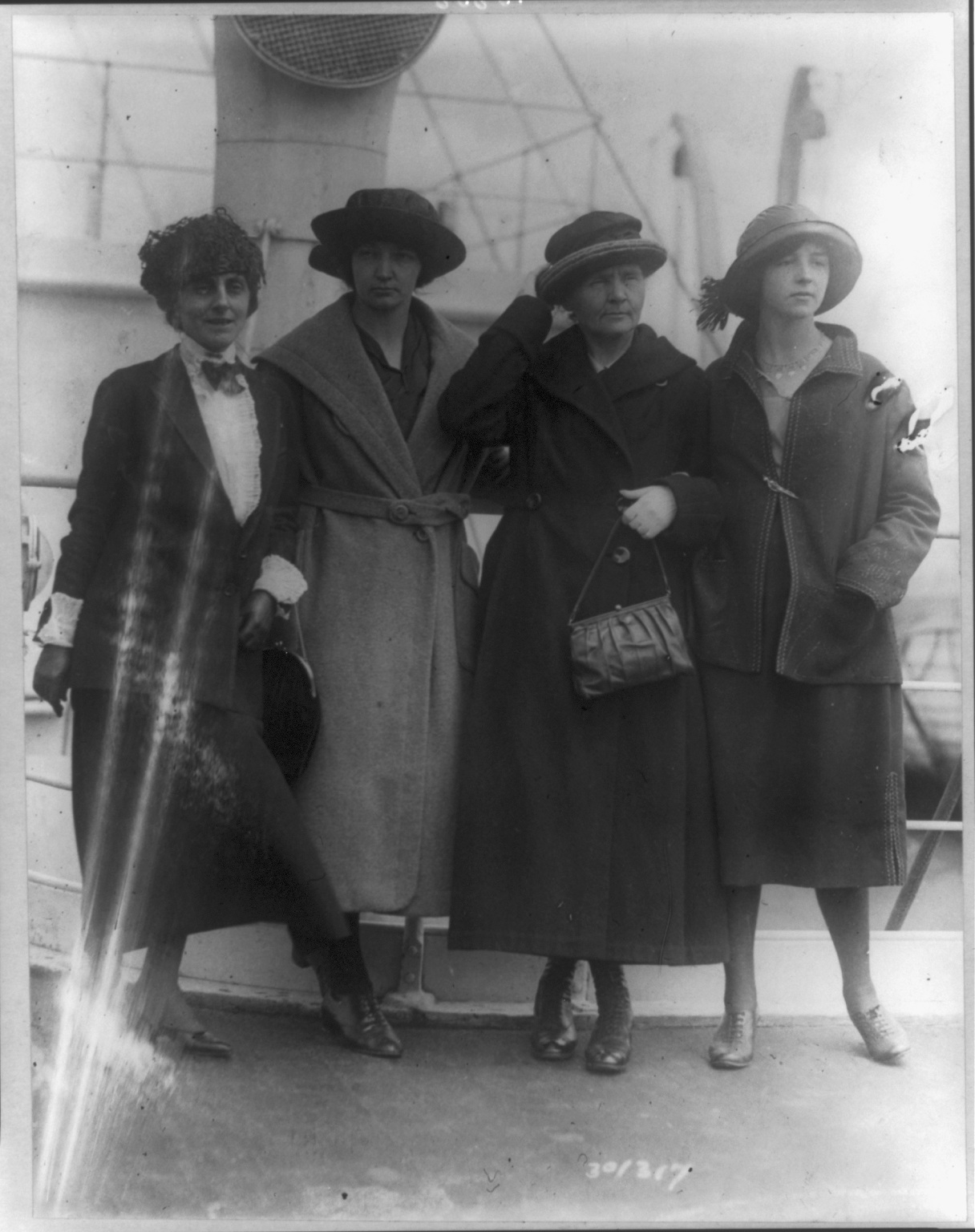 Marie Curie standing with her daughters and Mrs. William Brown Meloney