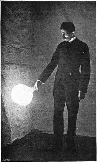 Nikola Tesla holding a glowing gas-discharge bulb
