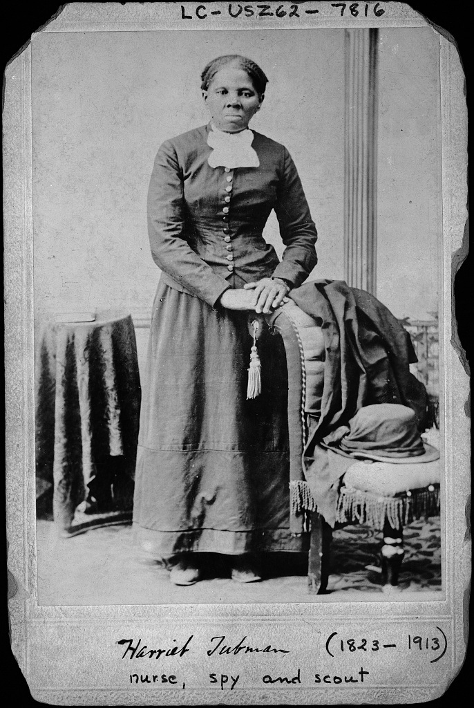 Harriet Tubman standing with her hands on a chair